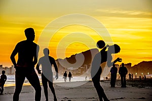 Playa fútbol americano sobre el hermoso dorado atardecer sobre el Playa 