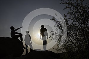 Silhouettes of people on rocks