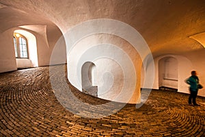 Silhouettes of people in spiral wide corridor in Round Tower or Rundetaarn in Copenhagen, Denmark
