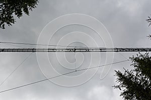 silhouettes of people on a suspension bridge