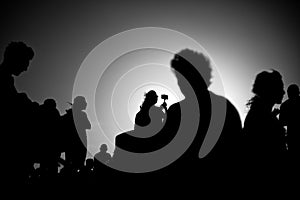 silhouettes of people taking pictures with smartphones