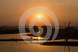 Silhouettes of people on Taungthaman Lake at sunset, in Amarapura, Mandalay Myanmar