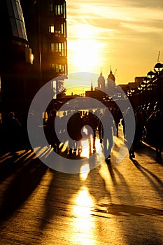 Silhouettes of people on the Thames river coast walks there and back behind their business, partners, shopping and so on. Shadows