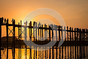 Silhouettes of people on U Bein bridge over the Taungthaman Lake at sunset, in Amarapura, Mandalay Myanmar