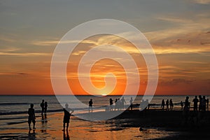 Silhouettes of people watching the sunset photo