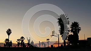 Players on basketball court playing basket ball game, sunset beach, California. photo