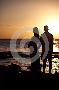 Silhouettes of pregnancy woman at sunset
