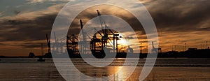 Silhouettes of ship to shore cranes at sunset