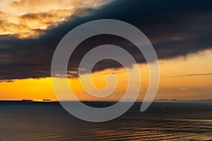 Silhouettes of ships at sea, dramatic seascape with sunset sky, sunlight reflected from the waves