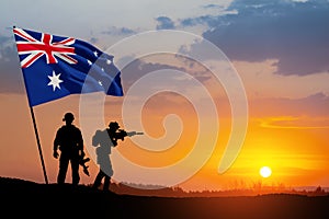 Silhouettes of soldiers with Australia flag on background of the sunset or the sunrise background. Anzac Day.