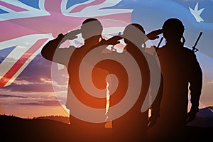 Silhouettes of soldiers on background of Australia flag and the sunset or the sunrise background. Anzac Day.