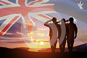 Silhouettes of soldiers on background of Australia flag and the sunset or the sunrise background. Anzac Day.