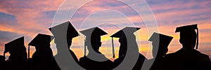 Silhouettes of students with graduate caps in a row on sunset background. Graduation ceremony web banner