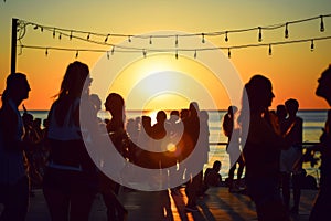 Silhouettes sway in a vibrant sunset at a tropical beach dance party, epitomizing summer joy.