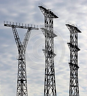 Silhouettes of three electricity pylons against evening sky