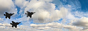 Silhouettes of three F-35 aircraft against the blue sky