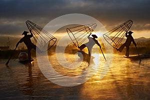 Silhouettes of three fishermen on Inle lake Myanmar