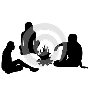 Silhouettes of tourists sitting around a campfire