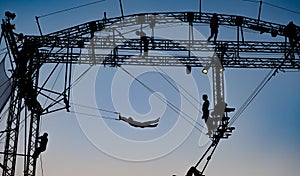 Silhouettes of trapeze artists acrobats