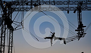 Silhouettes of trapeze artists acrobats