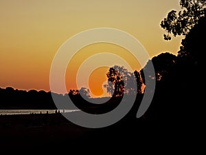 Silhouettes of trees and mountains after sunset along Montargil Lake, Portugal