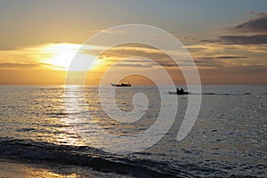 Silhouettes of two boats near batanta island at sunset