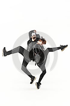 The silhouettes of two hip hop male and female break dancers dancing on white background