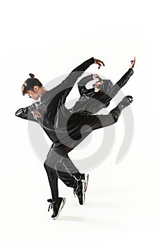 The silhouettes of two hip hop male and female break dancers dancing on white background