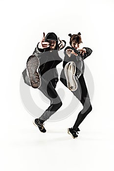 The silhouettes of two hip hop male and female break dancers dancing on white background