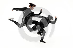 The silhouettes of two hip hop male and female break dancers dancing on white background