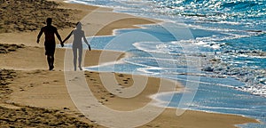 Silhouettes of two lovers on the beach