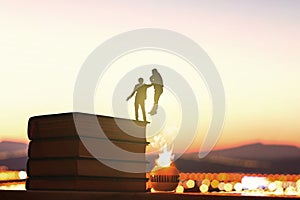 Silhouettes of two men fighting on the pile of books