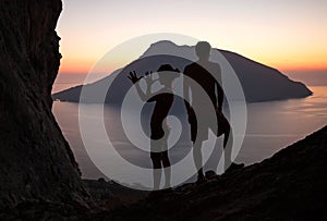 Silhouettes of two people having fun at sunset