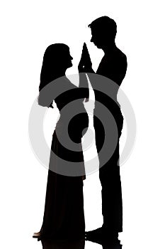 Silhouettes of two people men and a pregnant woman