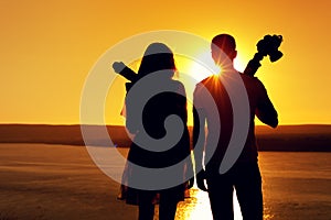 Silhouettes of two photographers with cameras