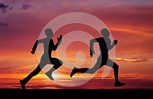 Silhouettes of two runners