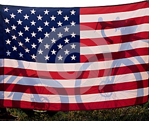 Silhouettes of two wheels from children\'s and adult\'s bicycles, in backlight behind large flag of America