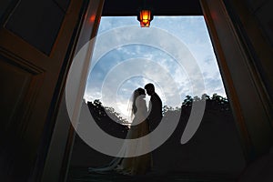 Silhouettes of a wedding couple standing in the front of deep bl