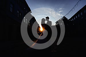 Silhouettes of wedding couple standing on the street