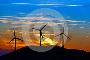 Silhouettes of Wind Turbines at Sunset
