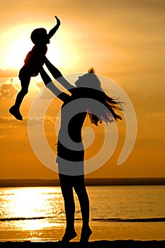 Silhouettes of women and child on sundown