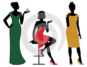 Silhouettes of women dressed in evening dress holding wine glass