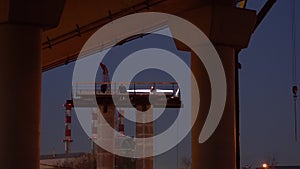 Silhouettes of workers-installers  working on a column, a support for an automobile overpass under construction