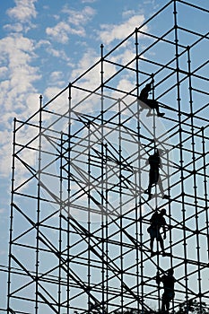 Silhouettes of workers on scaffolding