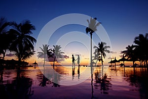 Silhouettes of young couple at scenic sunset