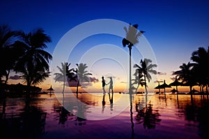 Silhouettes of young couple at scenic sunset