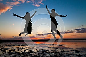 Silhouettes of young people jumping with excitement