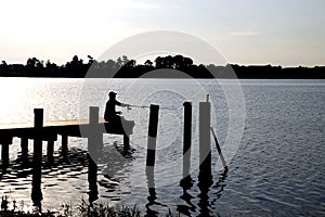 Silhoutte of fisherman on dock