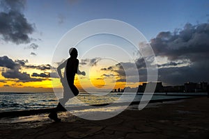 Silhoutte of runner jogging along Waikiki beach