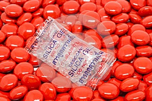 Silica gel in bag on red sugar coated pills tablets vitamin